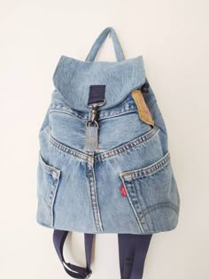 a denim backpack hanging on the wall