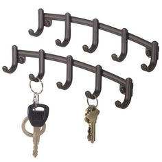 four keys hanging from hooks on a metal rack with key rings attached to it's sides