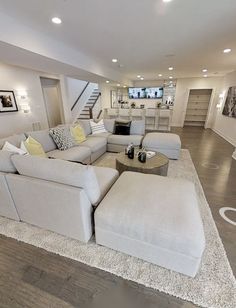 a living room filled with furniture and a fire place next to a staircase leading up to the second floor