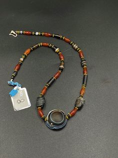 The beautiful contemporary beads necklace consist of ancient agate and carnelian beads along with big round banded agate Lukmik magic eye bead in the center of the necklace with two more special beads , elephant figure carved beads in black and white banded agate in the sides of the necklace as you can see in the above pictures the origin of this beads from south east Asian countries some black color glass beads and some gold color brass beads are used as spacers in the necklace we provide fast Carnelian Amulet Jewelry With Round Beads, Antique Beaded Agate Jewelry, Carved Amber Round Beads Jewelry, Round Carved Agate Necklaces, Carved Agate Round Necklaces, Antique Hand-strung Agate Jewelry, Amulet Style Beaded Necklace With Gemstone Beads, Amulet Style Round Gemstone Beaded Necklaces, Gemstone Beads Amulet Necklace