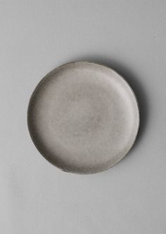 a white plate sitting on top of a gray table next to a knife and fork