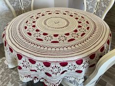 a table with a red and white doily on it sitting next to two chairs