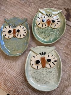 three owl shaped plates sitting on top of a wooden table