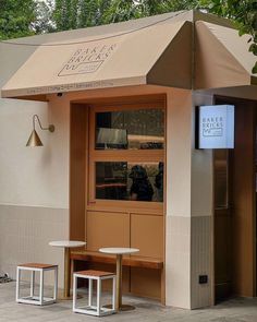 the outside of a restaurant with tables and stools