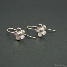 Hand made sterling silver flower earrings. The silver flowers measure 10mm. in diameter and have been hand  saw pierced from sturdy silver sheet To the centre of each flower there is a small silver bead. The earrings are secured with fixed silver hook fittings. All my jewellery comes in a presentation gift box.  All my designs are hand made and no two are exactly the same. Thank you for visiting. Please note that international shipping fees do not include possible custom charges for your country and you will be solely responsible for payment of these charges.  We are required by law to fully disclose the contents and value of the items in your package for Customs purposes.  Your local customs office will be able to provide you with further information on possible import duties and other ch Sterling Silver Flower Charm Earrings For Anniversary, Sterling Silver Drop Earrings For Anniversary, Sterling Silver Flower Charm Earrings, Sterling Silver Jewelry With 3d Flower Design, Delicate Silver Flower Earrings Nickel-free, Delicate Silver Flower Earrings Nickel Free, Delicate Silver Nickel-free Flower Earrings, Silver Delicate Nickel-free Flower Earrings, Sterling Silver Earrings With Flower Charm For Wedding