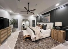 a bedroom with a large bed and ceiling fan