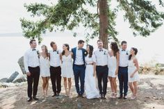 a group of people standing next to each other in front of a body of water