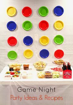 a game night party table with plates and snacks on it, including candy bar trays