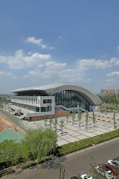 an aerial view of a large building with cars parked in the parking lot below it