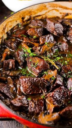 beef stew with mushrooms and herbs in a red pot