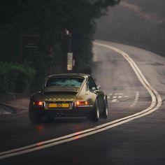 a car driving down the road on a foggy day