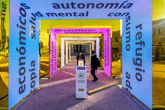 the entrance to an autonomia mental center with people walking under it and trees in the background