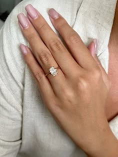 a woman's hand with a diamond ring on it