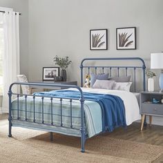 a blue metal bed frame in a bedroom