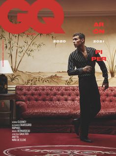 a man standing in front of a red couch on the cover of gq magazine