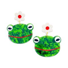 two green frog shaped earrings with red and white flowers in the middle, on a white background