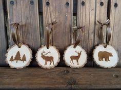 three wooden ornaments with animals and trees on them