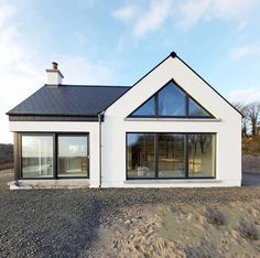 a white house sitting on top of a gravel field