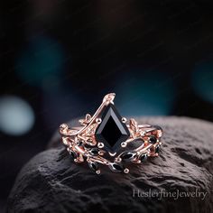 a black diamond ring sitting on top of a rock