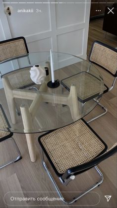 a glass table with four chairs around it