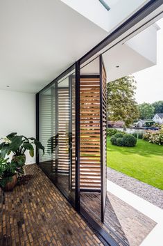 an open glass door leading to a patio area with wooden slats on the walls