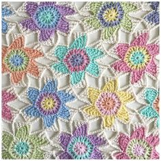 a crocheted blanket with multicolored flowers on it