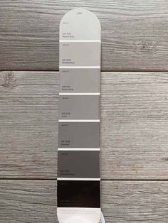 a pantone color swatch on top of a wooden table with gray and white paint