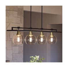 three clear glass globes hang from an industrial style chandelier