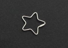 a metal star shaped object on a black surface