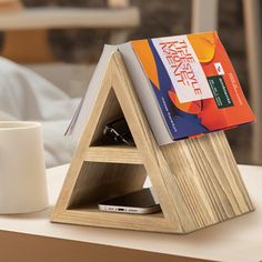 a wooden book stand with books on it and a coffee mug in front of it