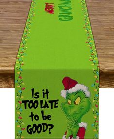 a green table runner with an image of the grin face on it and words is it too late to be good?