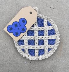 a blue and white crocheted basket with a tag on it's side