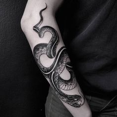 a black and white snake tattoo on the arm