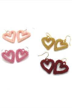 four pairs of heart shaped beaded earrings in various colors and sizes on a white background