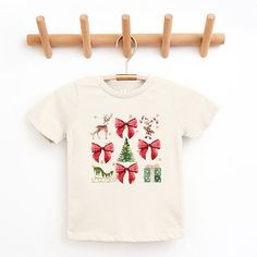 Looking for a cute tee for your kids? We have the perfect Coquette Christmas Collage graphic tee addition to their closet! Also available in youth tees. Shop Coquette, Collage Graphic, Trending Graphic Tees, Coquette Christmas, Christmas Collage, Toddler Christmas, Flower Graphic, Top Graphic Tees, Kids Outfits Girls