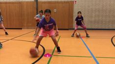 several children are playing basketball on an indoor court