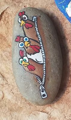 a painted rock with an image of a chicken on it