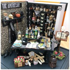 an assortment of items are displayed on a table in front of a wall with the words, the apothecary