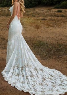 a beautiful blonde woman in a white dress posing for the camera with her back to the camera