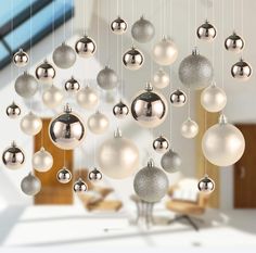 a bunch of silver and white ornaments hanging from strings