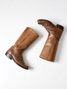 "This is a pair of vintage Frye campus boots. The classic tall boot features beautifully aged saddle brown leather with a wood stacked heel. CONDITION In good condition with wear consistent with age and use. General scuffs and scratches on the leather and soles. Some water spots on one boot inner leg. MARKED SIZE: 7.5 D US Women's Size: 9 MEASUREMENTS Height: 14\" .. 35.6 cm Wall to Toe Length: 11\" .. 27.9 cm Sole Width: 4\" .. 10.2 cm Circumference at Top: 14.75\" ... 37.5 cm Heel Height: 1.5\ Vintage Vegetable-tanned Leather Boots, Classic Vintage Brown Boots For Fall, Classic Brown Knee-high Moto Boots, Vintage Moto Boots With Snip Toe And Leather Lining, Vintage Snip Toe Moto Boots With Leather Lining, Vintage Fall Moto Boots With Leather Lining, Vintage Brown Knee-high Moto Boots, Vintage Leather Knee-high Boots, Vintage Vegetable-tanned Boots For Fall