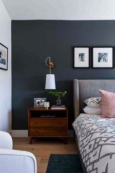 a bed room with a neatly made bed and two pictures on the wall above it