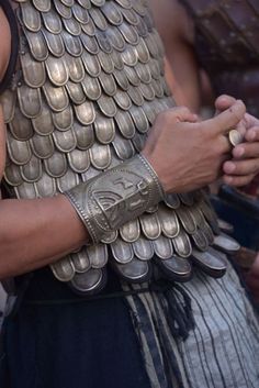 a close up of a person wearing armor and holding a cell phone in their hands