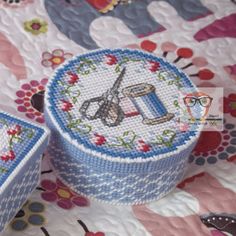 two sewing needle cases sitting on top of a quilt