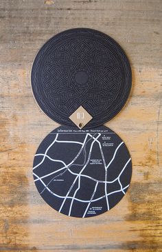 two circular coasters sitting on top of a wooden table