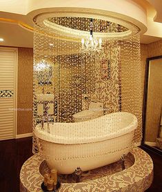 a bathroom with a tub and chandelier on the ceiling, in gold tones