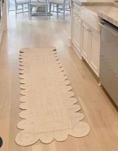 a kitchen with white cabinets and an area rug that looks like a christmas tree on the floor