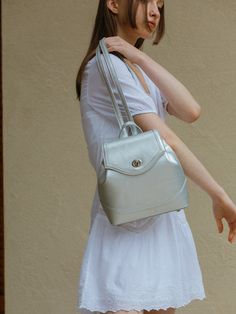 Editor's NoteBAG TO BASICS's bag is designed for its practicality for everyday wear.- Turn lock decoration with engraved brand logo- Inner zipper pocket- Length adjustable straps- Spacious and feminine backpack Measurements (in.)- Size: 9.06 in. * 9.25 in. * 3.94 in.- Strap: 0.59 in. * 28.35 in. ~ 35.43 in.Composition & Care- Poly / Artificial Leather- The leather may have fine scratches and wrinkles- Professional cleaning is neededDesigner- by BAG TO BASICS Modern Travel Backpack With Silver-tone Hardware, Everyday Backpack With Silver-tone Hardware, Travel Backpack With Silver-tone Hardware, Silver Bags With Detachable Strap For On-the-go, Silver Satchel For Everyday Use, Versatile Silver Bag For Everyday, Silver Double Handle Shoulder Bag For Travel, Versatile Silver Travel Bags, Modern Silver Bag With Magnetic Closure