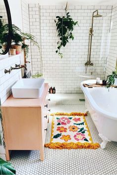 a bath room with a tub a sink and a rug