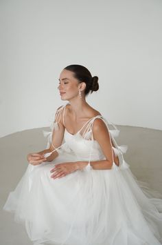 a woman in a white dress sitting on the floor